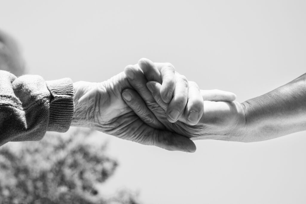 Clasped hands of two people helping each other